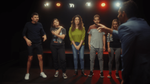 SERIE_LPA_MULE (1) cinco personas en fila y un hombre apuntando a uno de ellos